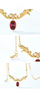 Macro detail of garnet pendant with vintage gold plating and floral filigree pattern