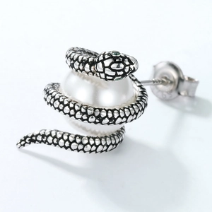 Vue macro des boucles d'oreilles serpent en argent S925 avec perle et yeux en pierres