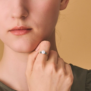 Elegant S925 silver gold-plated ring with round white pearl and blue topaz side stones