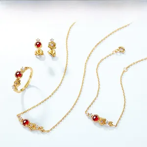 Macro detail of rose jewelry set with garnet stones and zircon inlay on blue backdrop