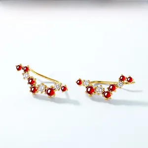 Detail of S925 silver wave earrings with red garnet and white zircon in gold plating
