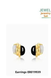 Detail of vintage gold-rimmed earrings with black agate and white mother of pearl