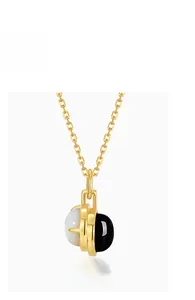 Detail of 925 silver gold plated necklace featuring black and white agate pendant