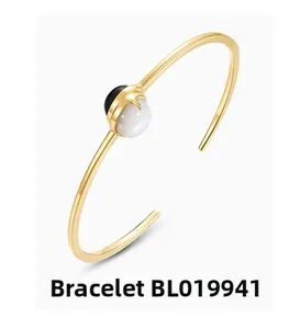 Close-up of golden open bangle BL019941 with elegant black onyx and white pearl inlays