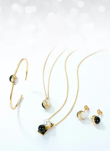 Detailed set of silver jewelry with white shell and black agate beads on blue background