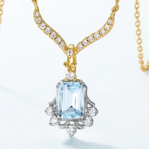 Macro detail of emerald-cut blue topaz pendant with gold and silver dual-tone finish