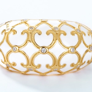 Macro detail of white enamel ring with gold baroque filigree and sparkling cubic zirconia