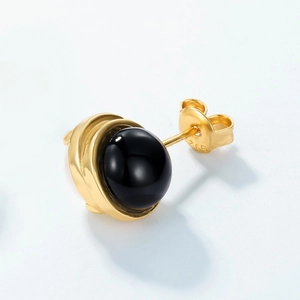 Macro shot of S925 sterling silver stamp on golden spiral earring with black onyx