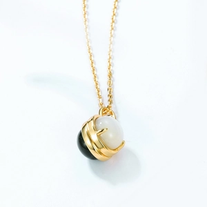 Macro shot of gold plated silver necklace with black agate and white shell beads