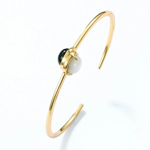 Detailed view of S925 sterling silver gold-plated cuff with black onyx and white shell