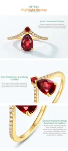 Detail view of crown-shaped silver ring with teardrop garnet and polished gold plating