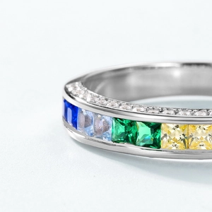 Macro shot of 925 silver ring featuring gradient square-cut colorful gemstones and pavé accents