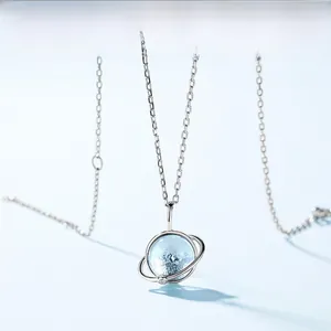 Detail of S925 silver planet pendant necklace featuring a sky blue topaz stone