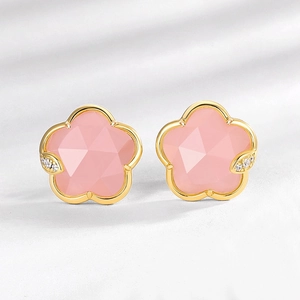 Close-up of flower stud earrings with pink crystal and small white stones in gold setting