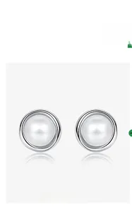 Détail macro de boucles d'oreilles en perle d'eau douce et argent S925 avec double halo