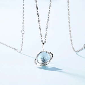 Minimalist S925 silver planet necklace with sky blue topaz pendant on blue background
