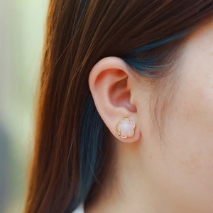 Pink flower stud earrings in 925 sterling silver with gold edges worn by a model