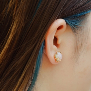 Close-up of pink crystal flower stud earrings with zircon leaf on model's ear