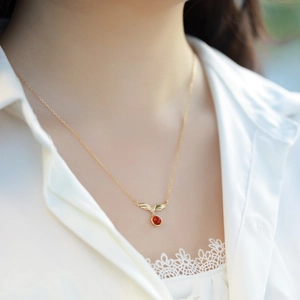 Elegante collana con ali dorate, granato rosso e pendente in zircone per donna