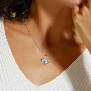 Elegant S925 silver planet necklace with blue topaz stone worn on a model's collarbone