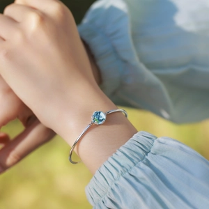Elegant 925 sterling silver bangle with sky blue topaz gemstone on woman's wrist