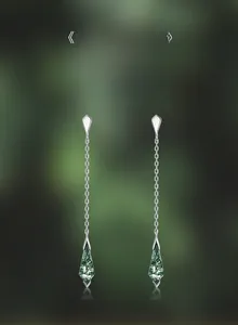 Macro shot of geometric long moss agate earrings with silver chain tassels and natural patterns