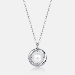 Détail d'un pendentif en perle avec spirale en argent et accents de zircone brillants