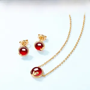 Détails macro d'une parure en argent 925 doré avec pierres de grenat rouge rondes