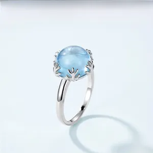 Detail of s925 silver ring featuring coral branch prongs and cabochon sky blue topaz