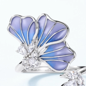 Macro detail of blue gradient enamel flower ring with zircon stones in silver frame