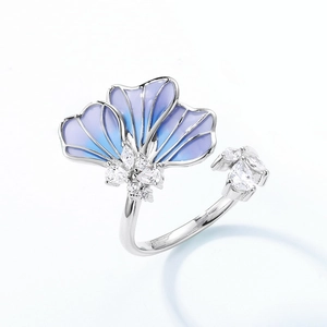 Close-up of adjustable silver ring featuring blue enamel ginkgo leaf and sparkling crystals