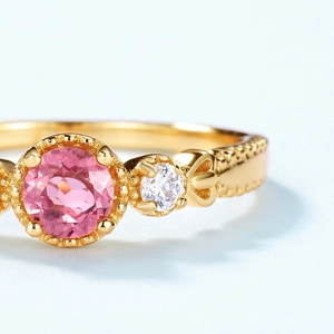Close-up of pink tourmaline ring with gold beaded band and bow detail in S925 silver