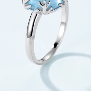 Macro shot of S925 sterling silver ring with sky blue topaz and unique snowflake prongs
