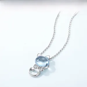 Macro detail of silver cat pendant with light blue topaz and cubic zirconia bow