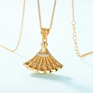 Elegant gold fan-shaped hollow necklace with small diamonds on light green background