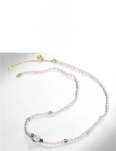 Detailed macro view of S925 heart charm on pearl necklace with green beads