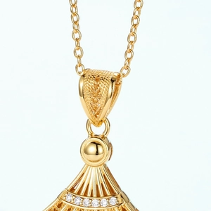 Macro detail of a golden hollow fan pendant necklace with sparkling crystal inlay