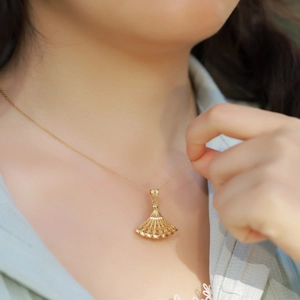 Elegant gold fan-shaped hollow necklace with crystals on model for a vintage look