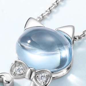 Macro shot of S925 silver cat necklace with sky blue topaz stone and zircon bow detail