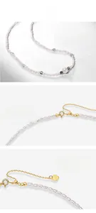 Macro detail of S925 heart charm on freshwater pearl and moss stone necklace