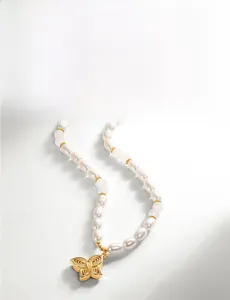 Vue détaillée du collier en perles d'eau douce avec jade et pendentif papillon doré