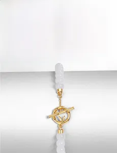 Macro view of gold-plated bamboo T-bar clasp and white jade beads on a bracelet