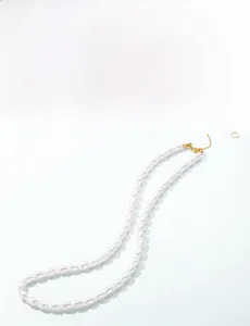 Close-up of natural freshwater seed pearls with gold heart pendant on S925 silver chain