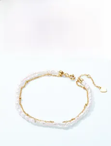 Detail view of double-layer bracelet with natural freshwater pearls and a gold heart charm
