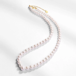 Élégant collier en perles naturelles argent 925 avec pendentif cœur doré sur fond blanc