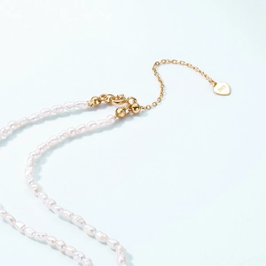 Dettaglio della chiusura in argento 925 e ciondolo a cuore sulla collana di perle d'acqua dolce
