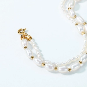 Macro shot of double-layer baroque pearl bracelet with gold beads and lobster clasp detail