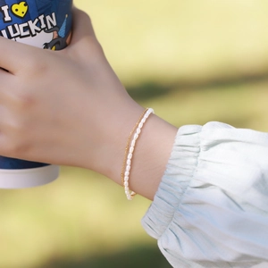 Double-layered gold chain bracelet with white freshwater pearls and minimalist beads