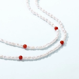 Détail du collier de perles avec perles d'agate rouge et perles d'eau douce blanches