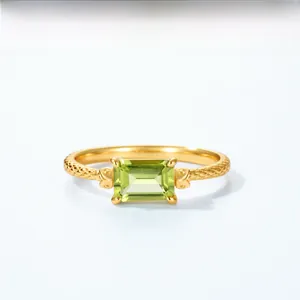 Detail of a vintage gold ring with emerald-cut peridot and snake scale texture